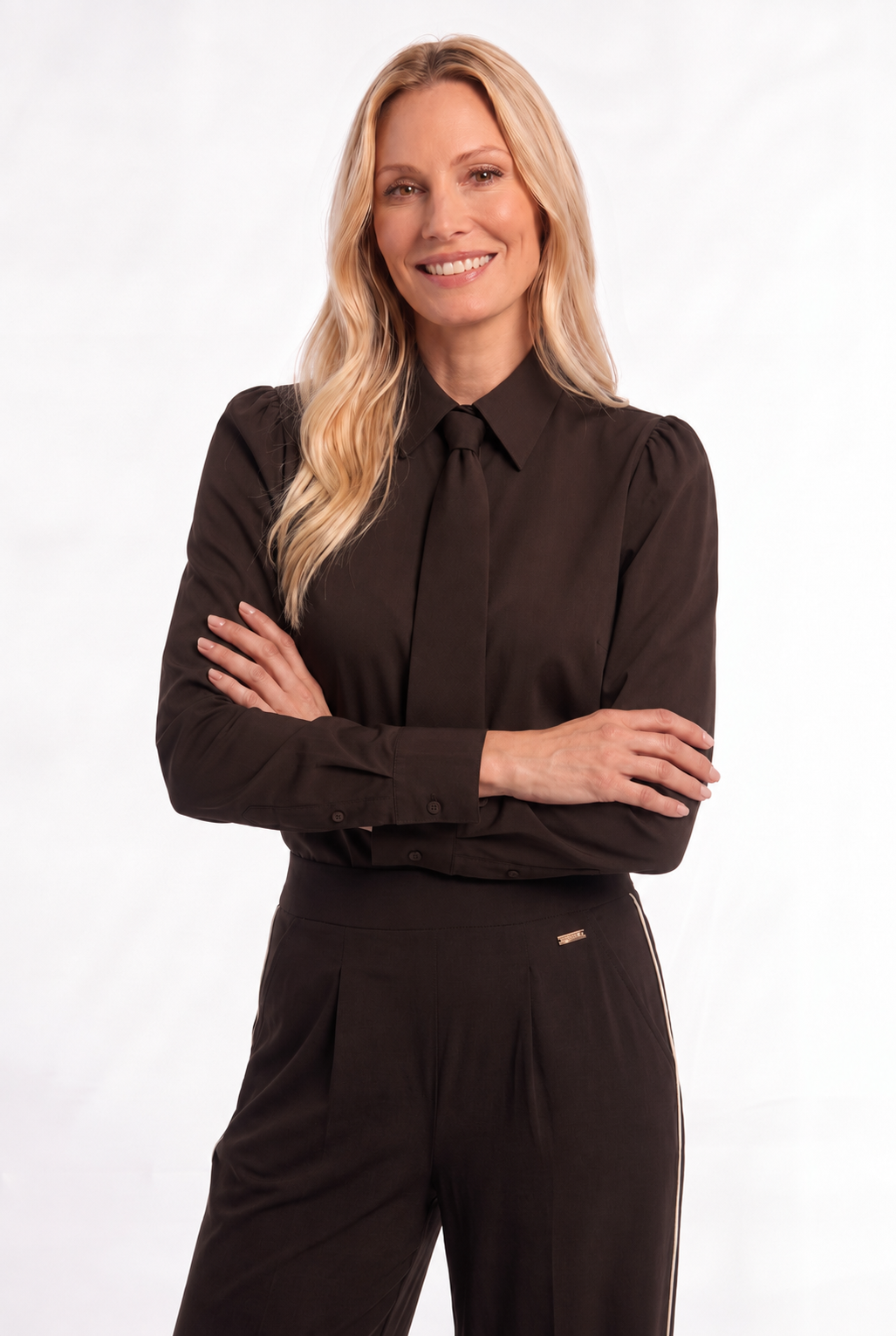 dame draagt een trendy travel blouse met ton-sur-ton stropdasdetail op een bruine travel broek