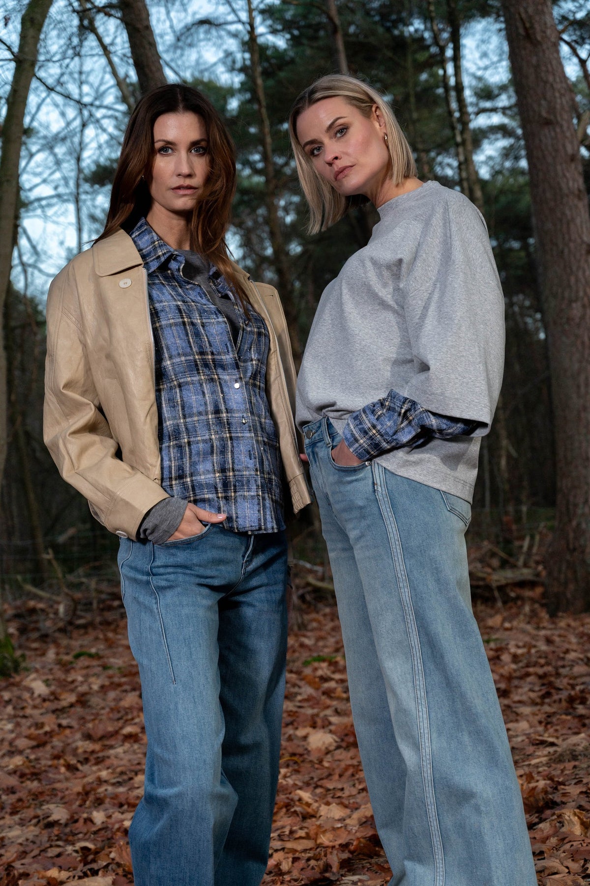 twee dames die de nieuwe herfstcollectie laten zien met een blauw geruit blousje en een grijs oversized t-shirt met diezelfde geruite mouwen verwerkt in het shirt