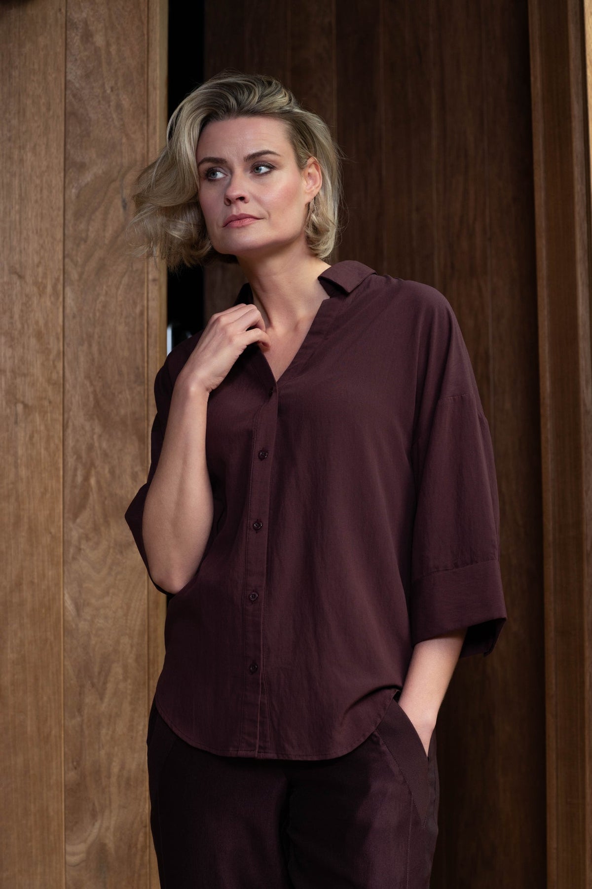 model poseert in de vieve wijnrood blouse van maicazz met losse pasvorm en wijde driekwartmouwen en v-hals