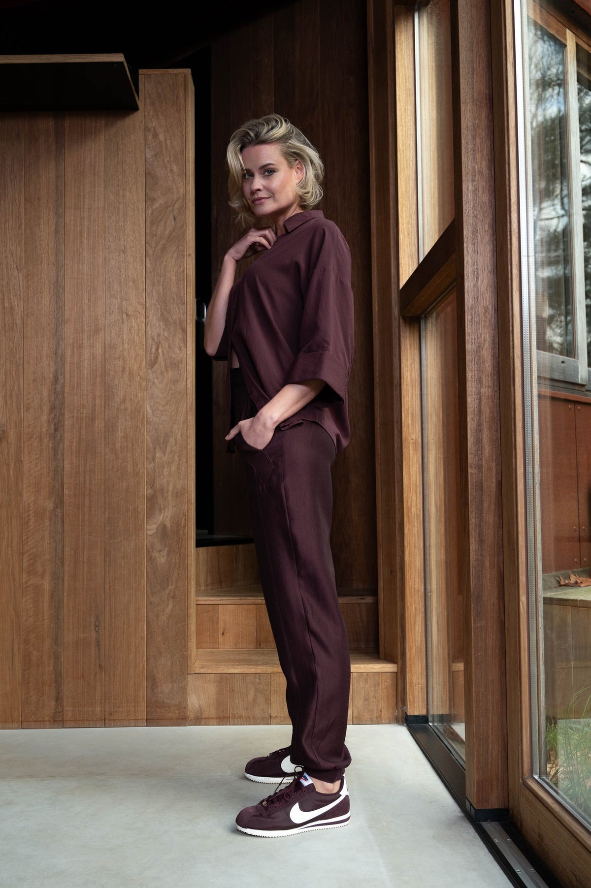 zijaanzicht van model in de vieve wijnrood blouse met losse pasvorm en wijde driekwartmouwen en v-hals