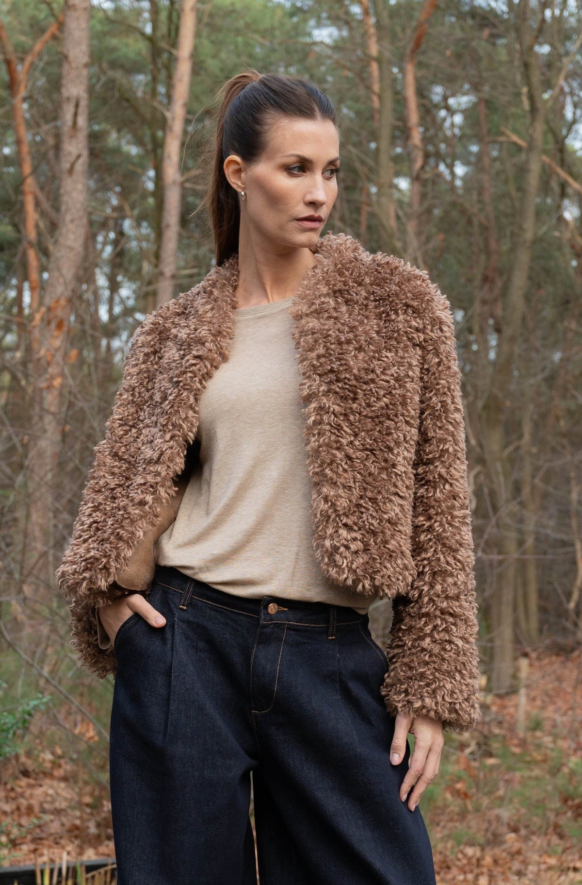 combineer de open teddy jas zonder sluiting met een beige damesshirt met lange mouwen en een donkere denim voor een complete herfstoutfit