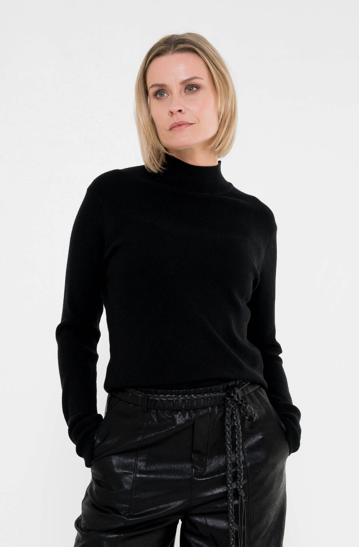 zwarte coltrui phenix op een zwarte lederlook broek 