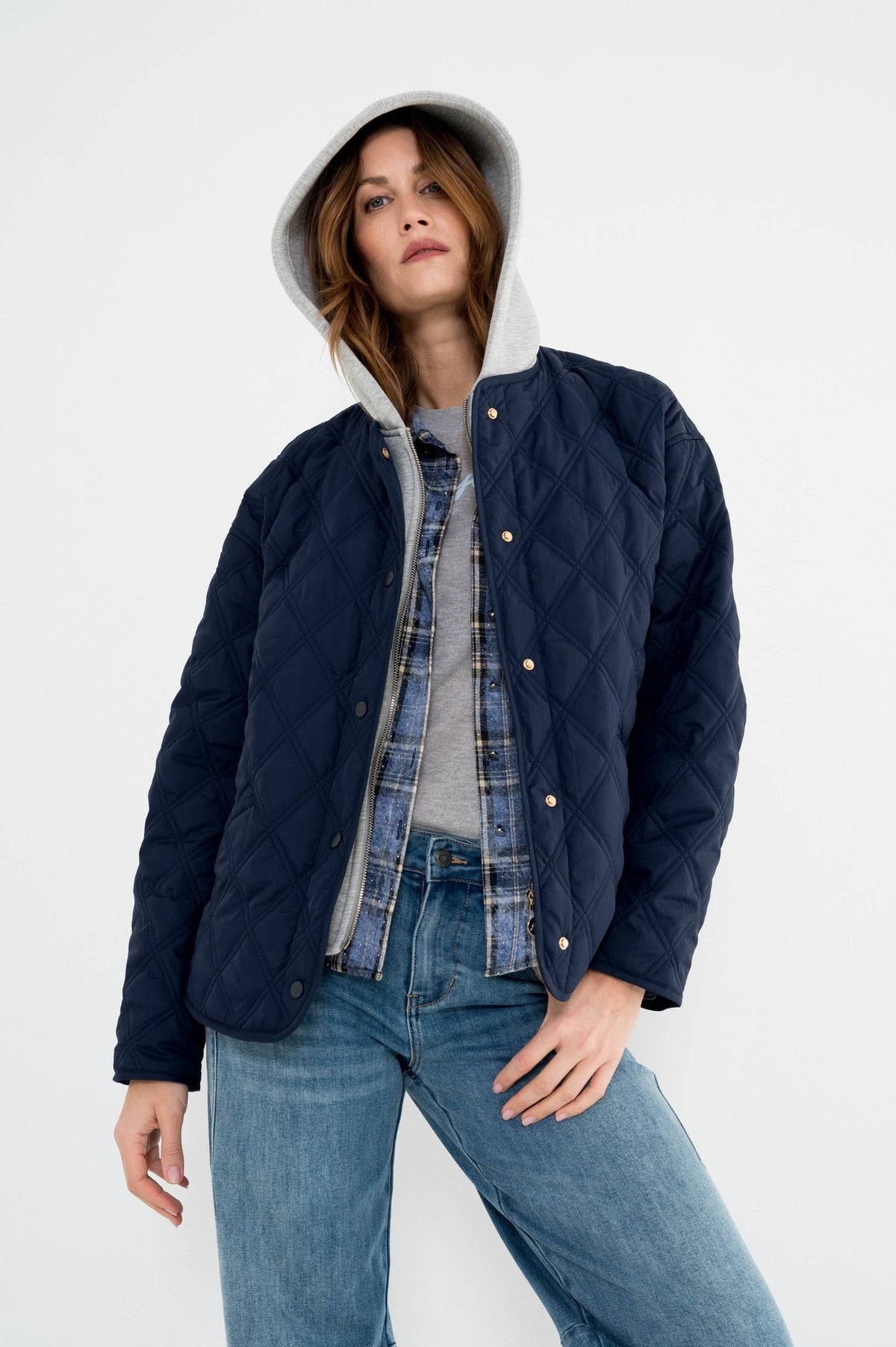 model draagt de vorges donkerblauw dames jasje van maicazz met lange mouwen in gewatteerd ruitpatroon