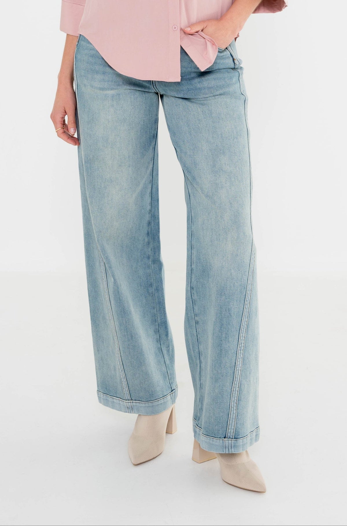 model draagt palazzo jeans met een lichte wassing gecombineerd met een roze zachte blouse 