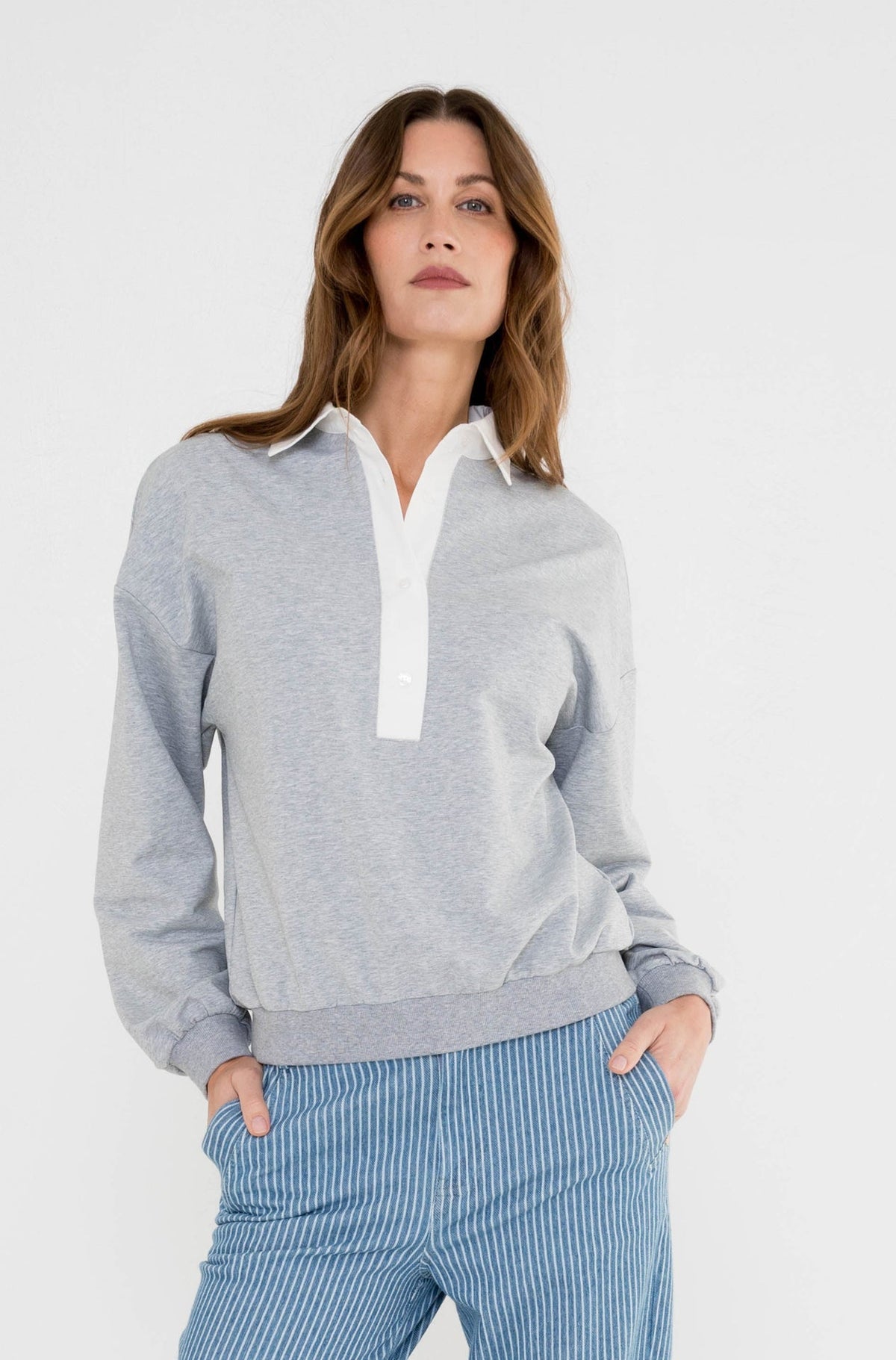 grijze sweater met poplin kraag zorgt voor een sportieve look op de blauw gestreepte jeans 
