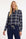model draagt stoere blauw geruite travelblouse op een donkerblauwe travelbroek met ritszakken