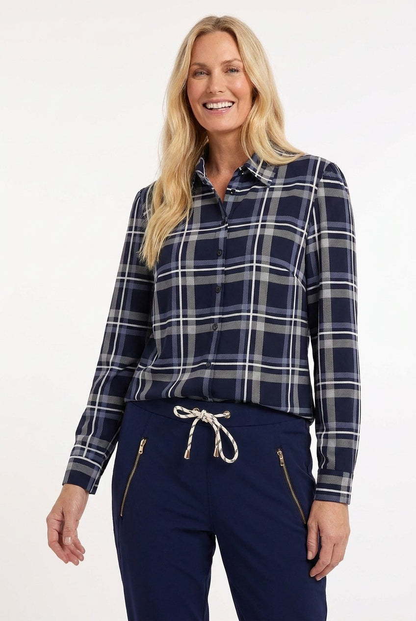 model draagt stoere blauw geruite travelblouse op een donkerblauwe travelbroek met ritszakken