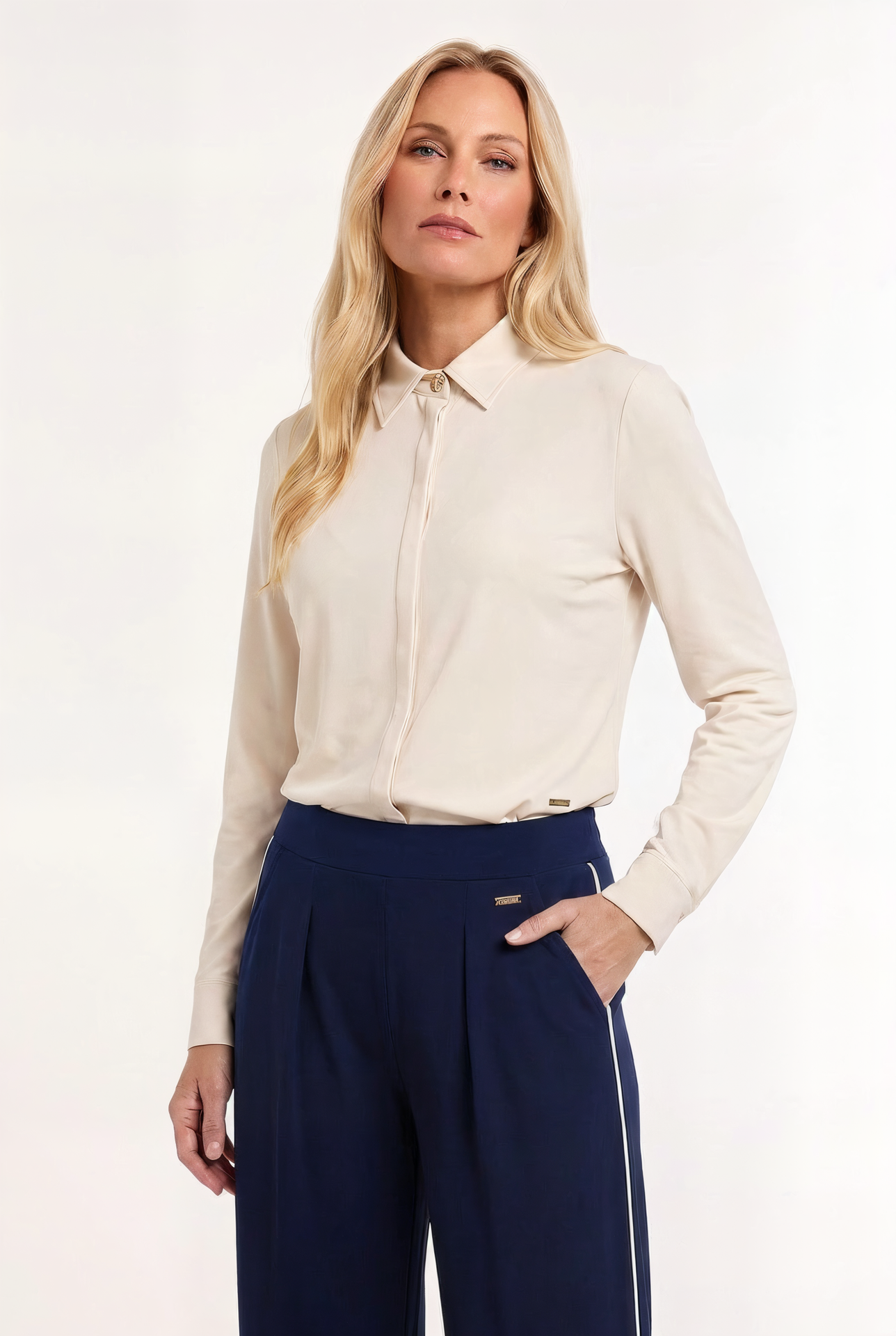 model draagt een offwhite travel blouse op een donkerblauwe travel broek 