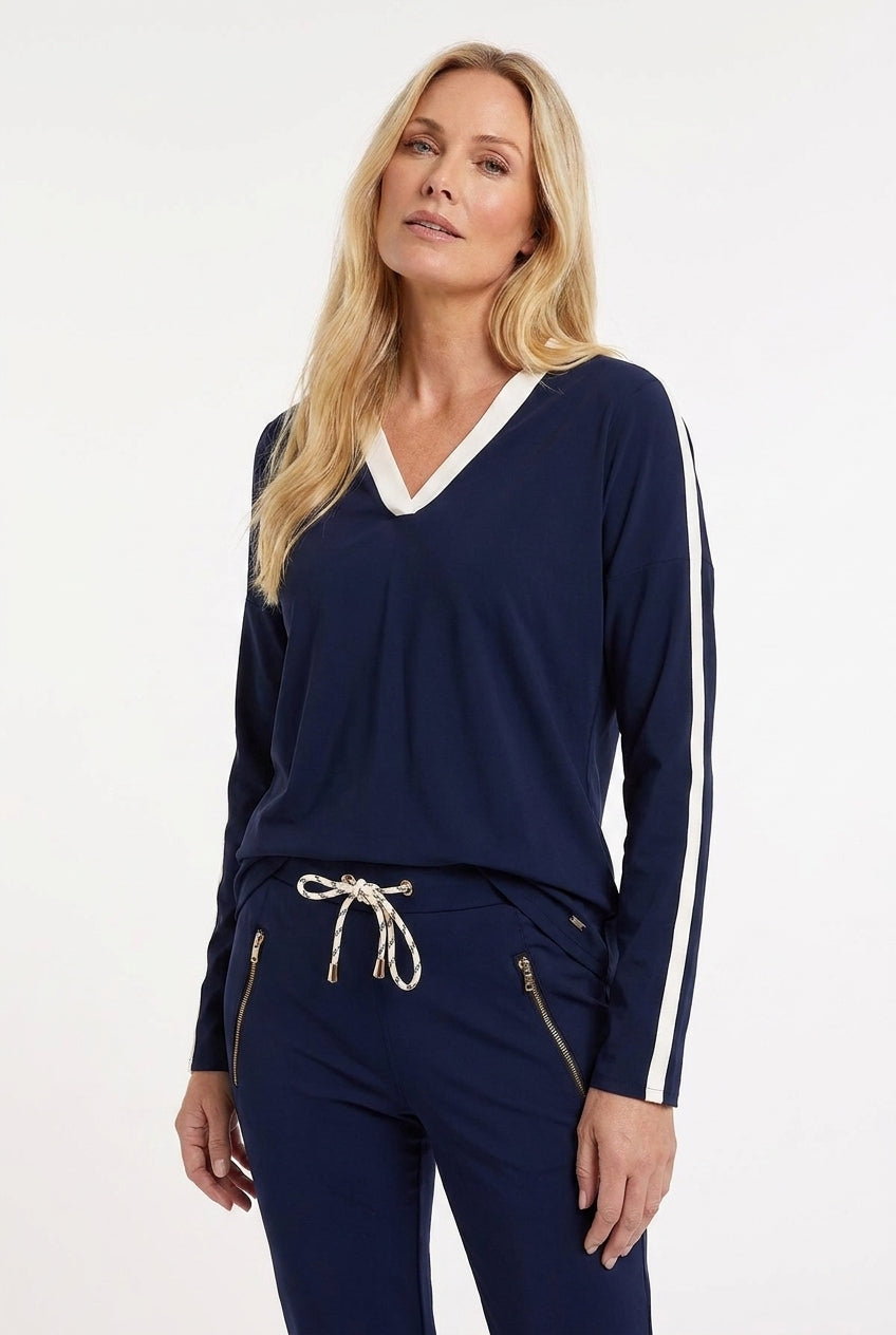 sportieve donkerblauwe travelset met shirt met lange mouwen en witte streep op de zijkant van de mouwen, de v-hals is ook wit