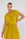 tanevi top gele kleur met v-hals en korte mouwen, gecombineerd met sachi rok voor een complete zomer outfit