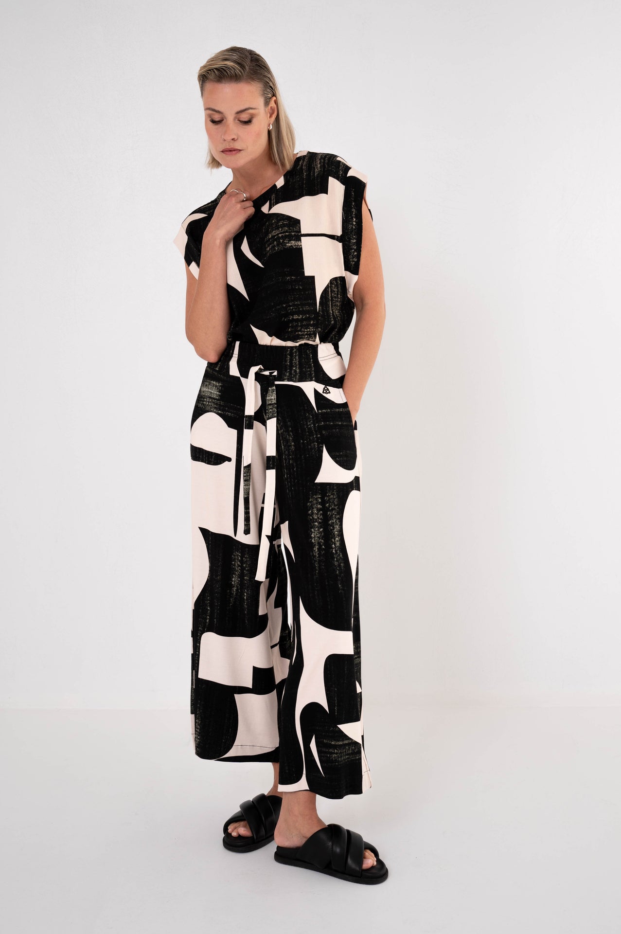 dame draagt een complete outfit van een top en broek met hetzelfde motief en stof