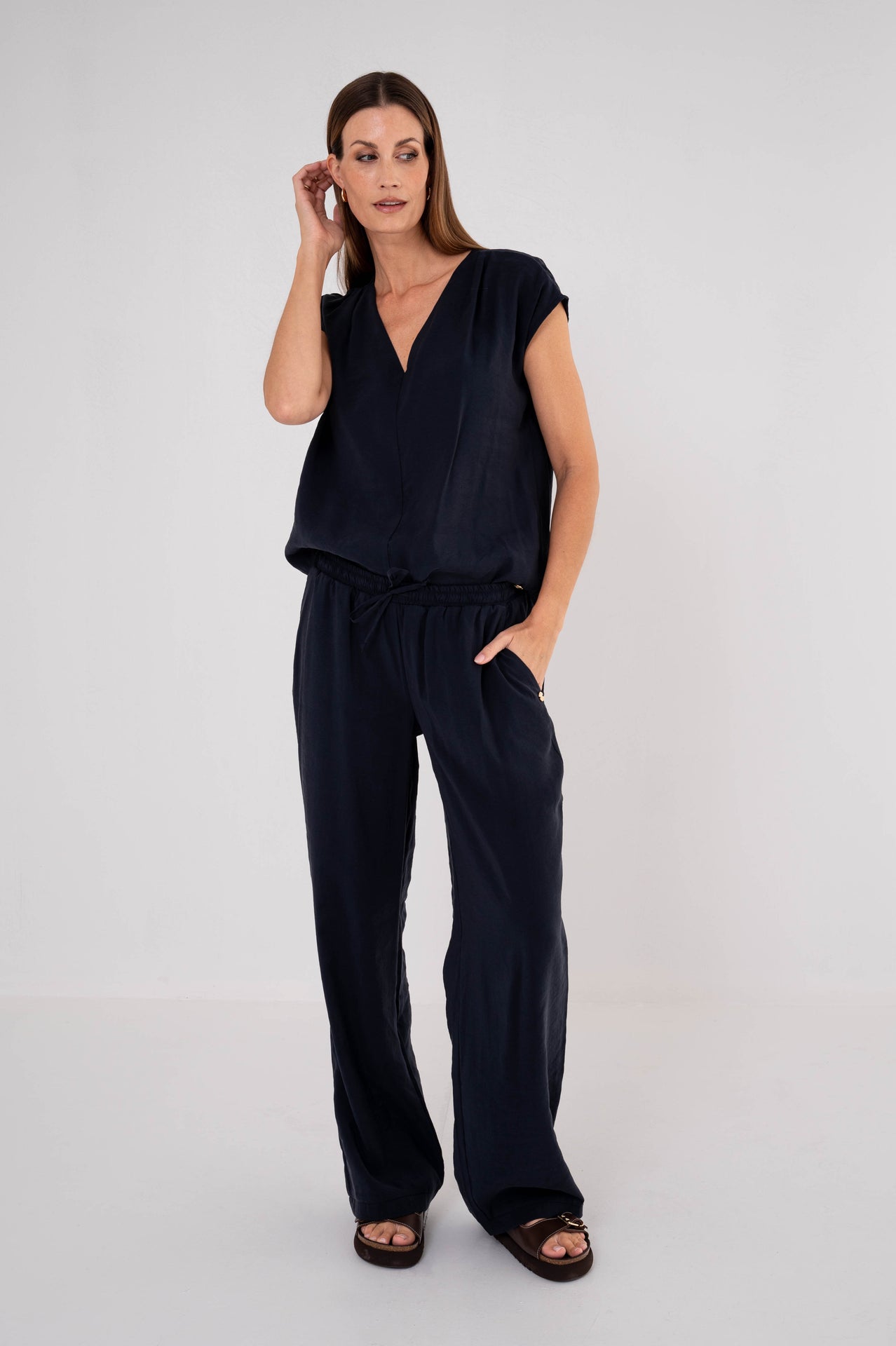 dame draagt donkerblauwe top en bijpassende broek voor een complete outfit 