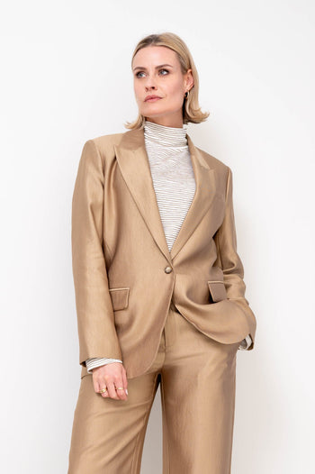 gouden blazer gecombineerd met een gouden broek voor een complete feestelijke winterlook