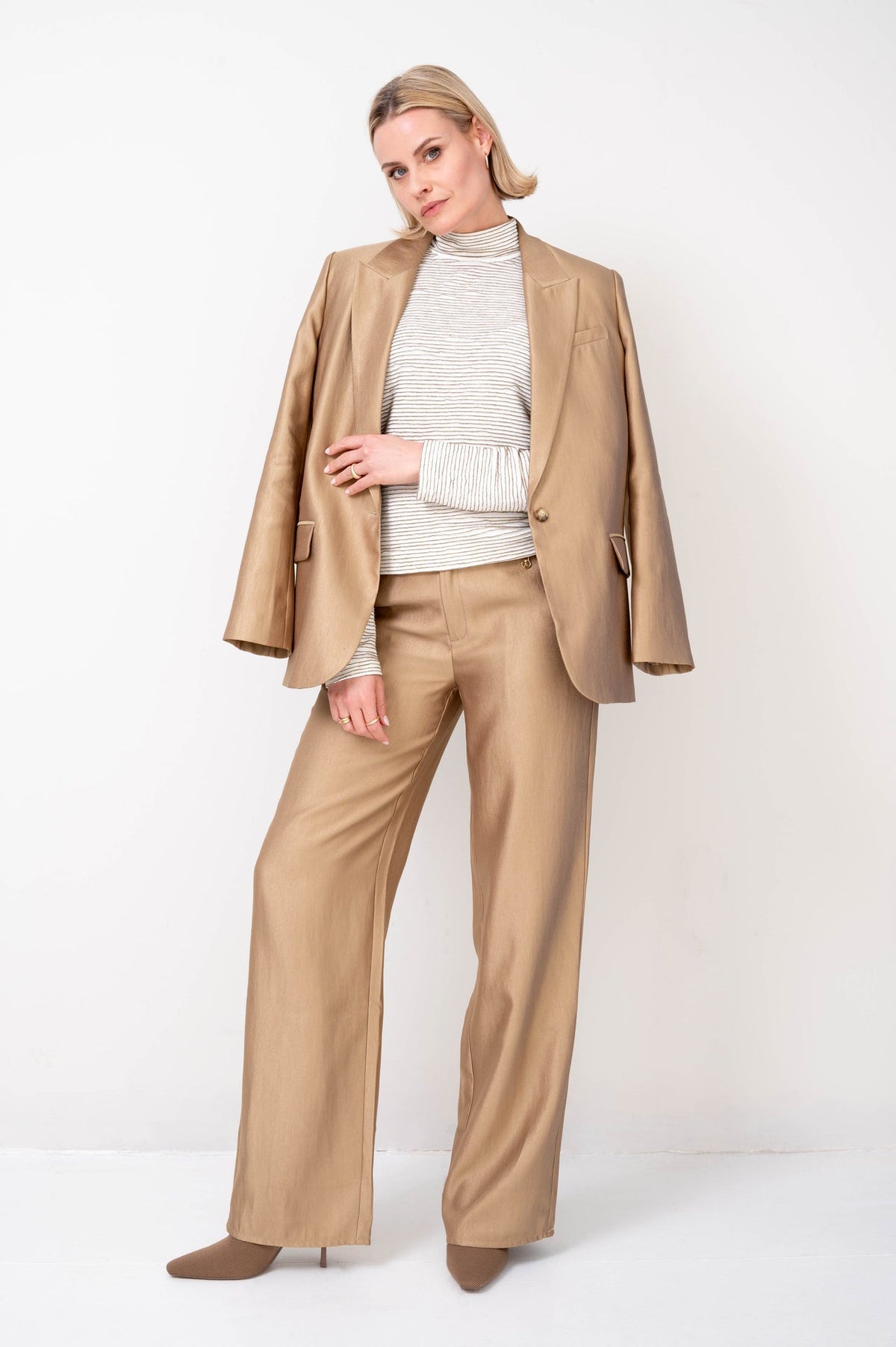 gouden blazer zora van zizo over een gestreepte coltrui met passende broek