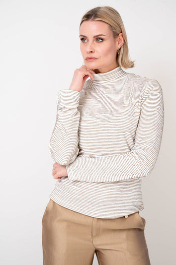 model draagt de presley coltrui offwhite gestreept met bruintinten met lange mouwen van maicazz