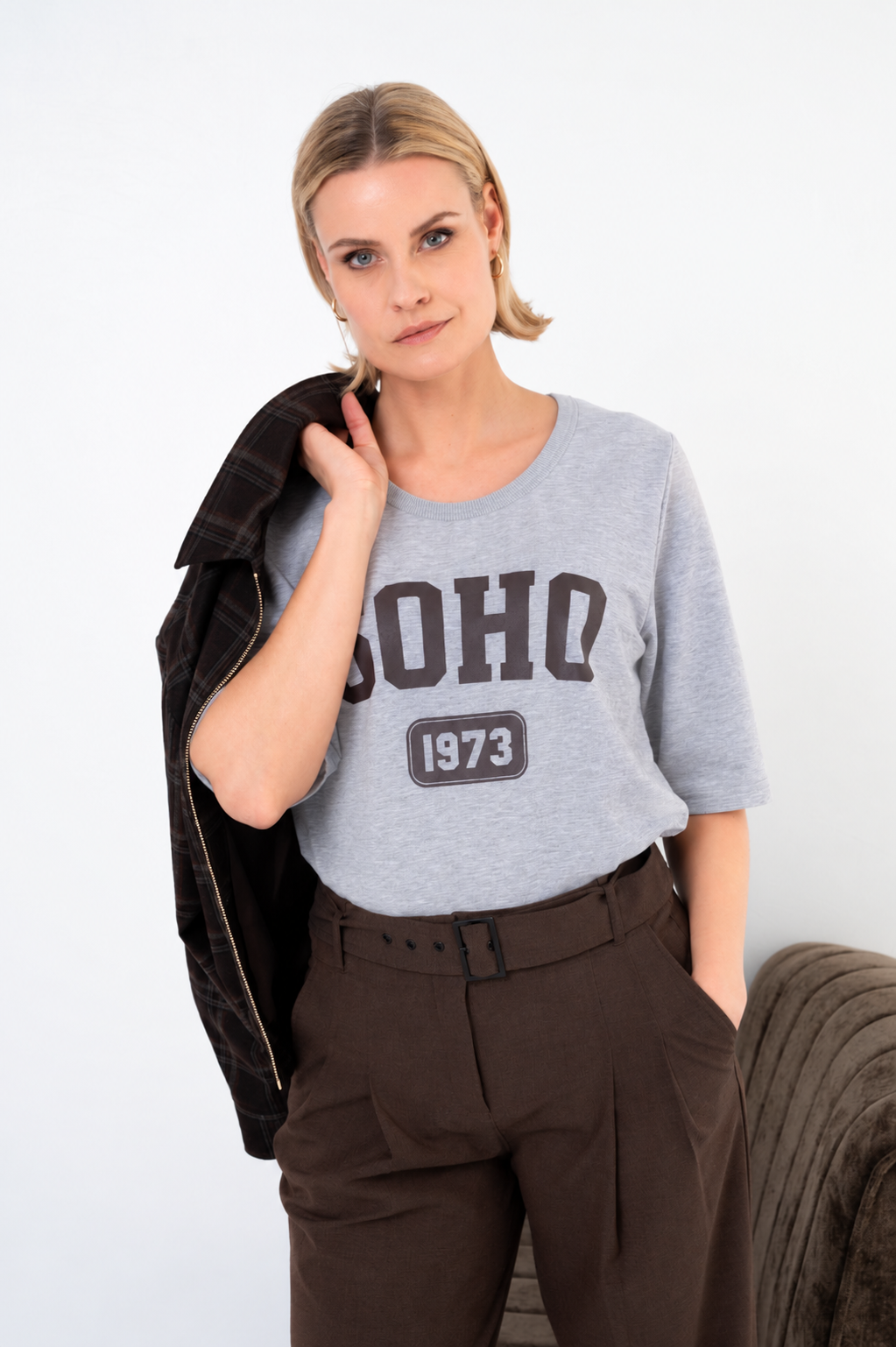dame draagt lichtgrijs t-shirt zonora op een  bruine broek met bijpassende riem