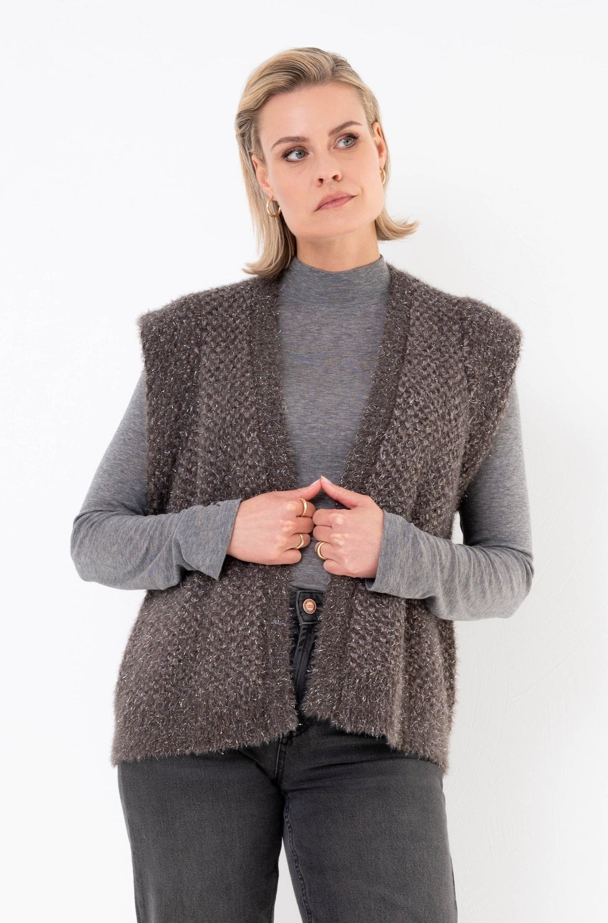 taupe vestje met korte mouwen en subtiele glitter op een grijze spijkerbroek