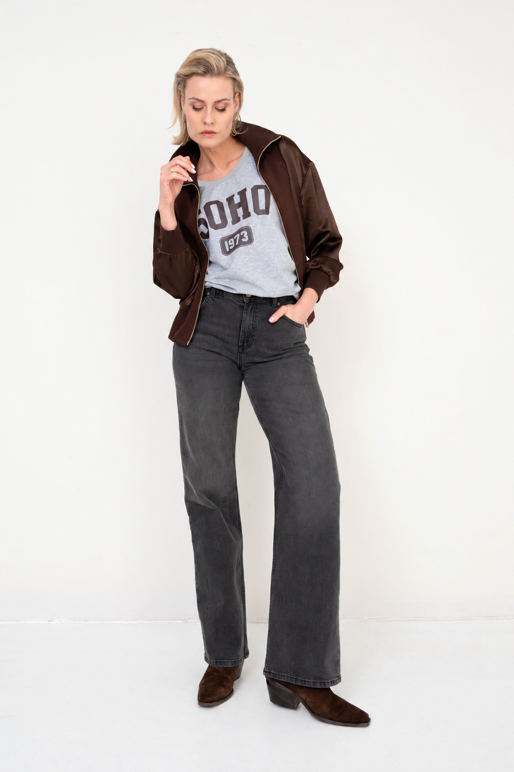 stoere damesoutfit met lichtgrijs t-shirt, bruin jasje en grijze denim