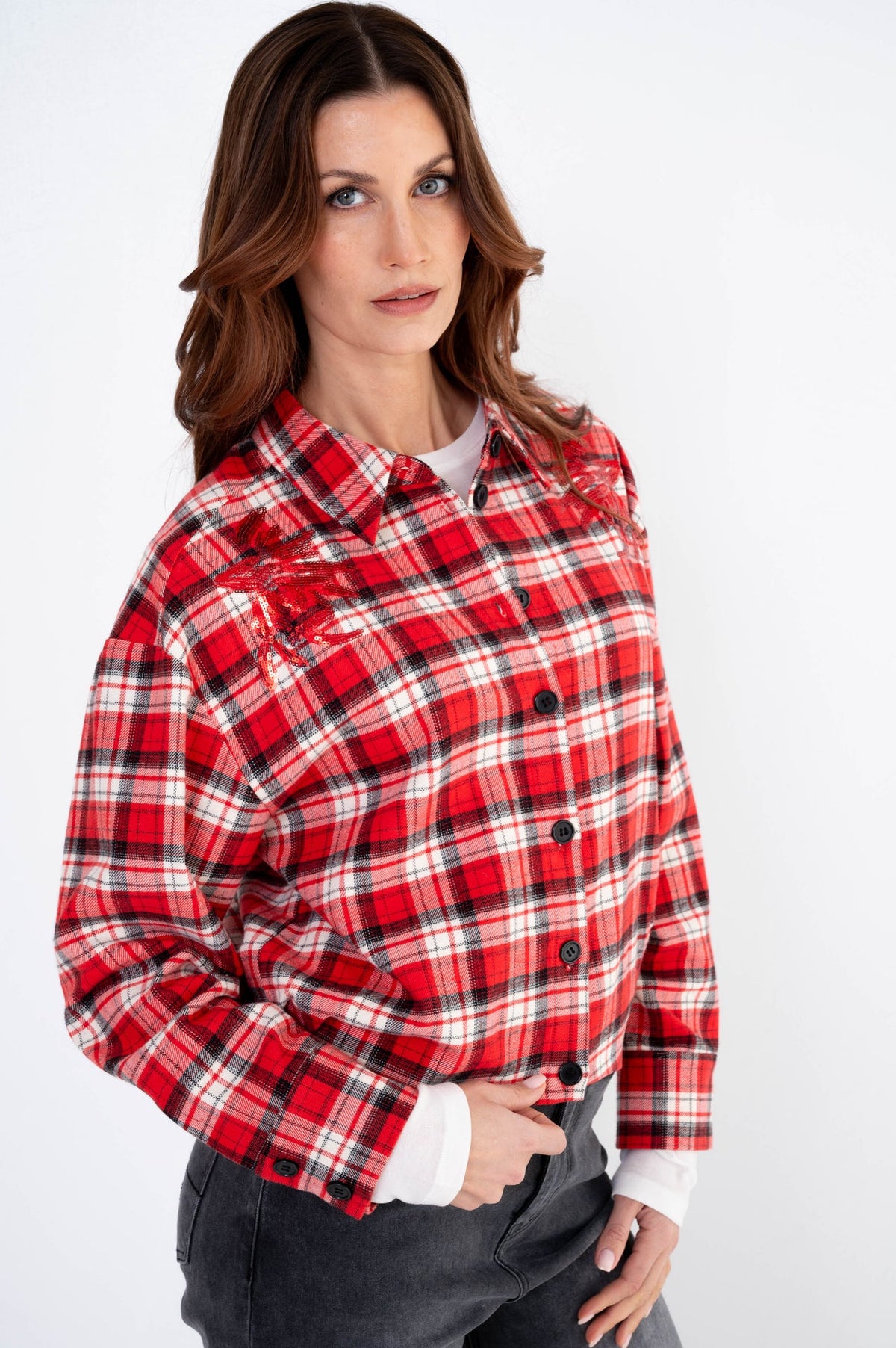 vooraanzicht van model in de zodos rood geruite blouse met zwarte knoopsluiting met glitter details op schouders en lange mouwen