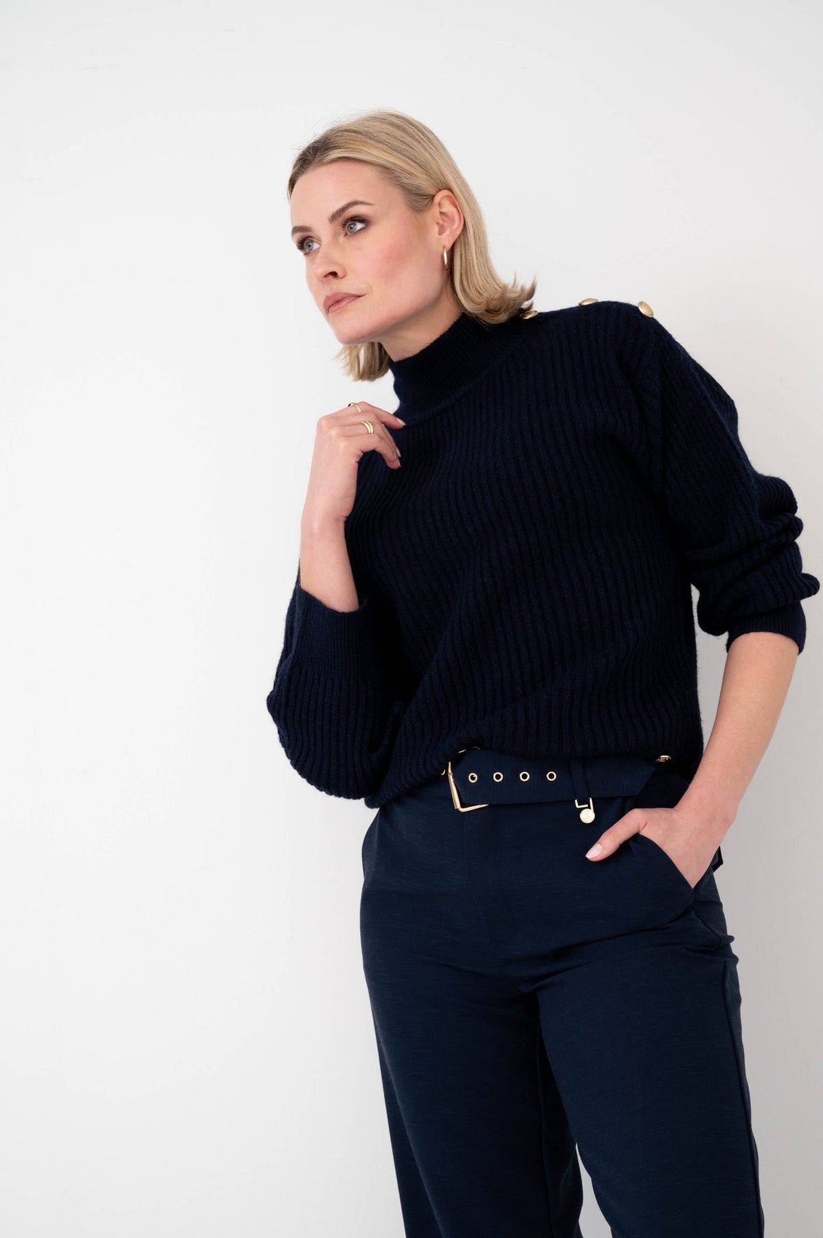 dame draagt donkerblauwe coltrui zuzia op een donkerblauwe broek met riem