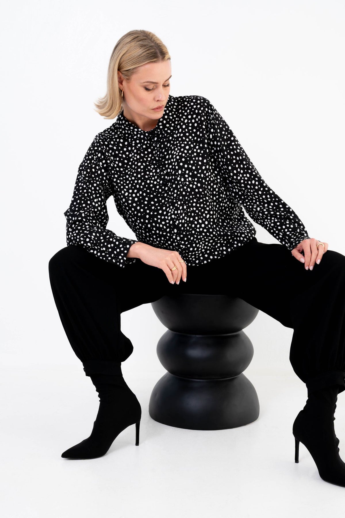 dame draagt een zwarte barrel broek vida met een zwart-witte blouse