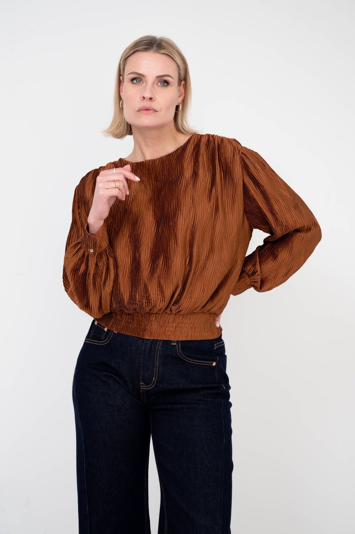 dame draagt zelda caramel plissé shirt op een donkere spijkerbroek